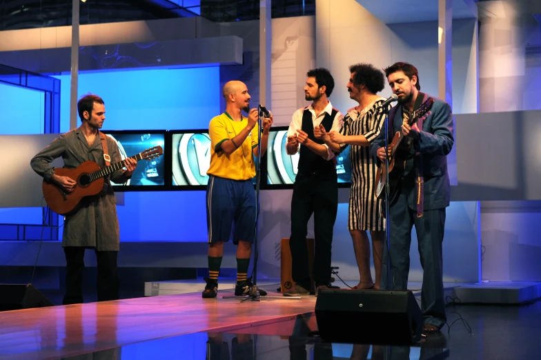 group of people standing around a television screen