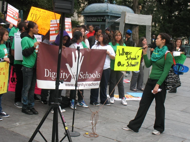 people are holding up signs and banners while on the sidewalk