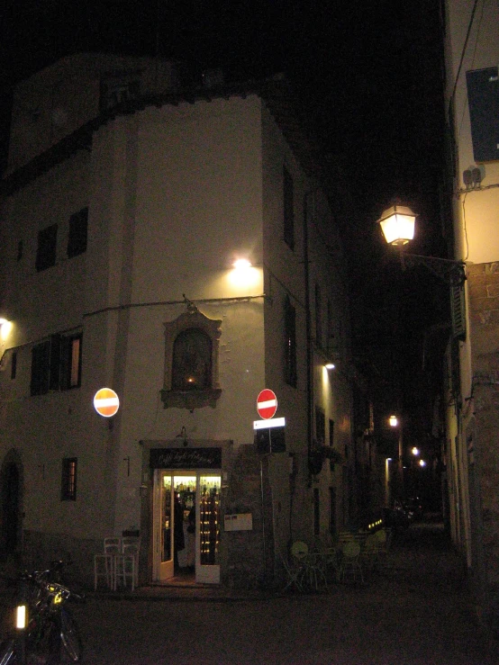 a building with lights and a motorcycle on the street