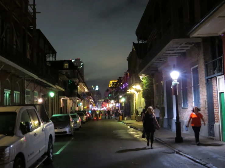 people walking down an urban street at night