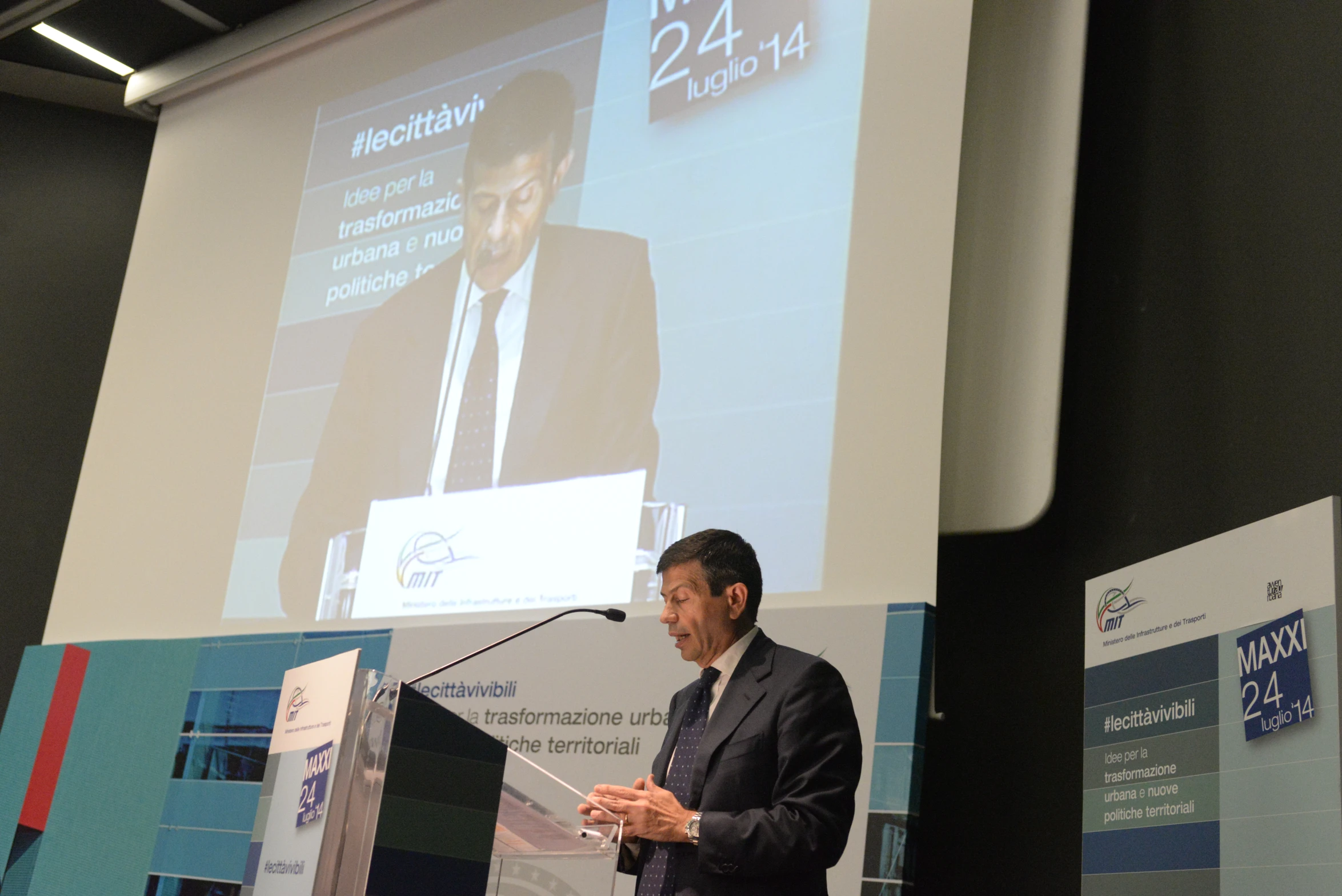 a man in a suit is speaking at a podium