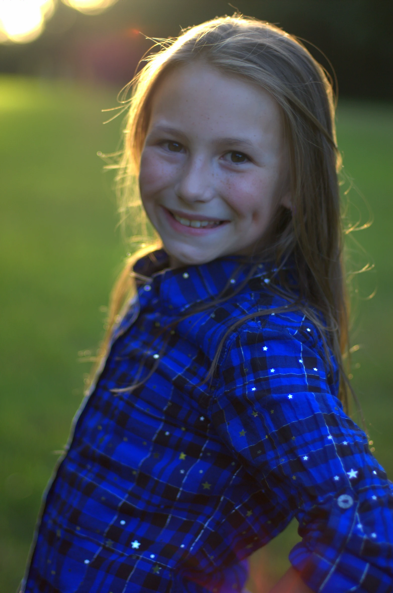 a little girl that is standing in the grass