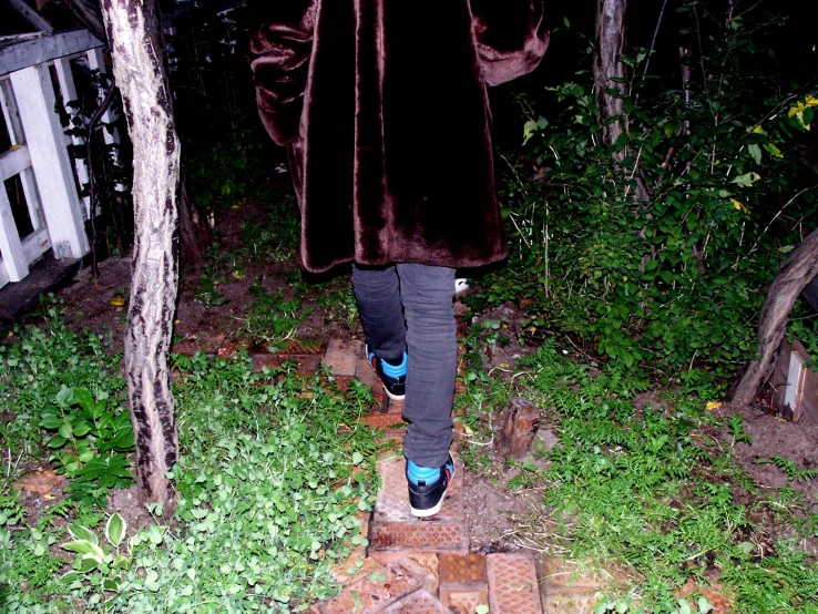 a man in a dark coat walking into a yard