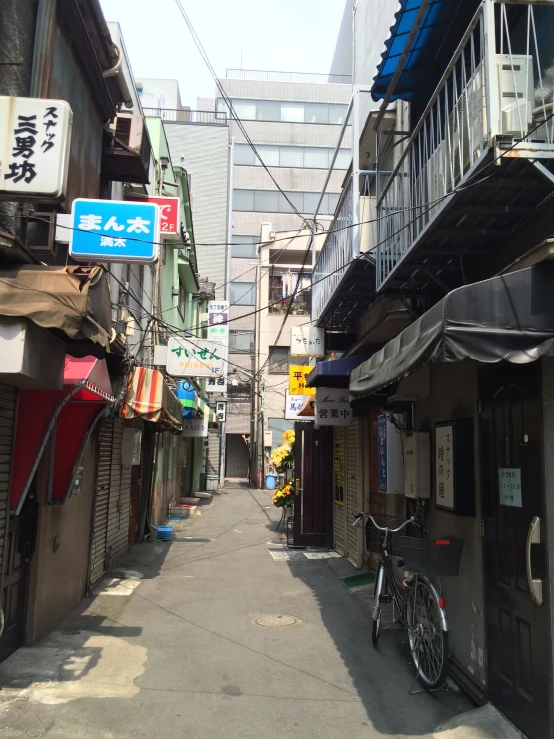 narrow alley way with buildings, bikes and signs