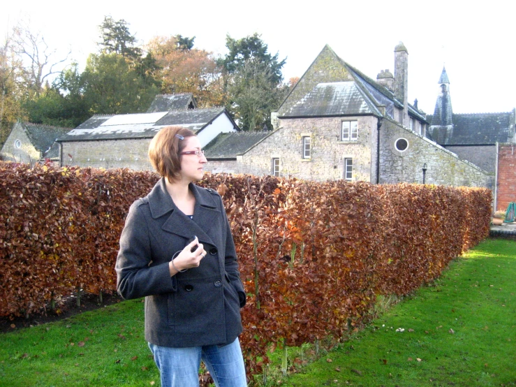 there is a woman standing near a fence