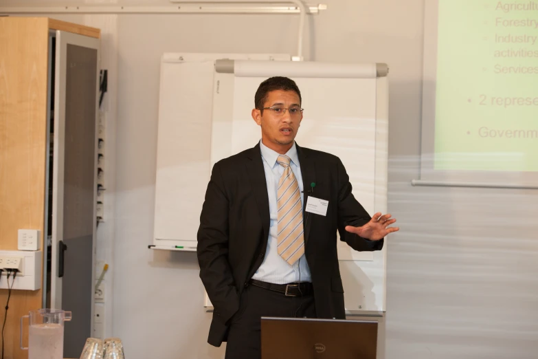 a man is standing at a podium and giving a presentation