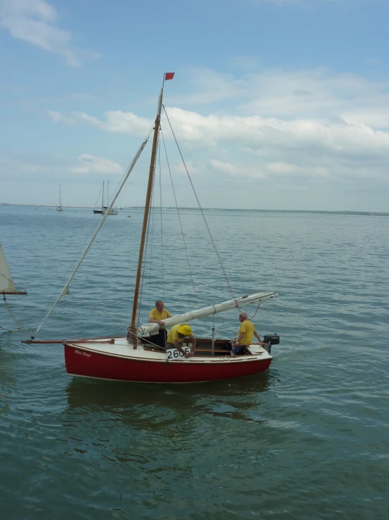 two men in a small sail boat in the ocean