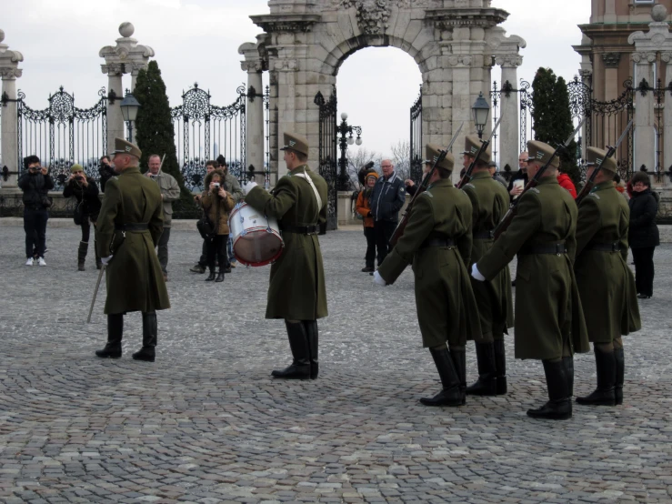 the men in uniform are playing on drums