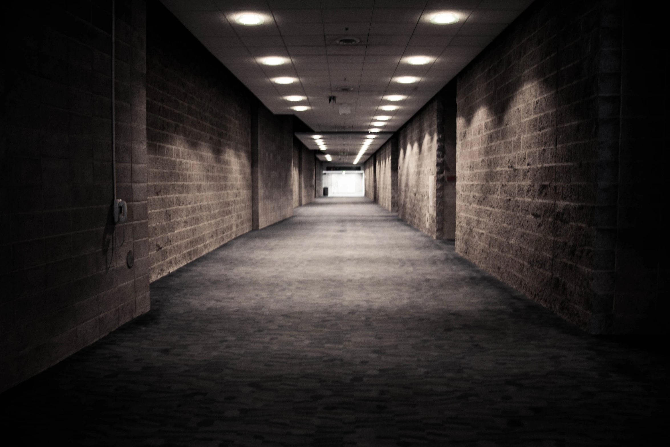 an empty corridor leading to two sets of elevators