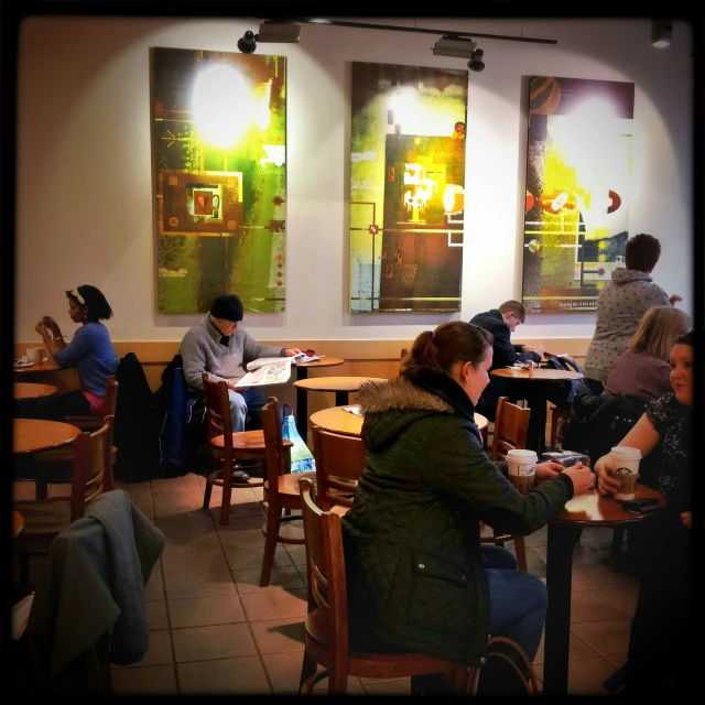 a room that has several people eating around the tables