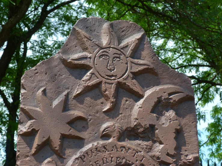 a stone with drawings and letters carved into it