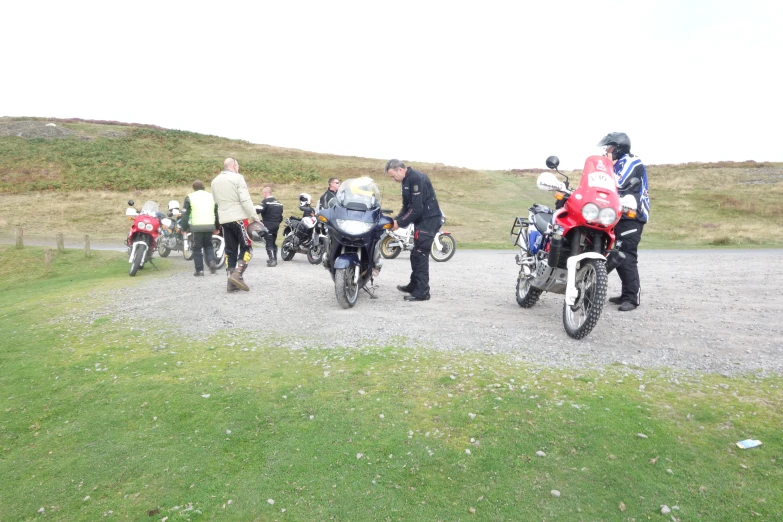 four motorcyclists and three other bikers standing in a group