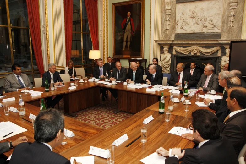 group of men sitting around a large wooden table