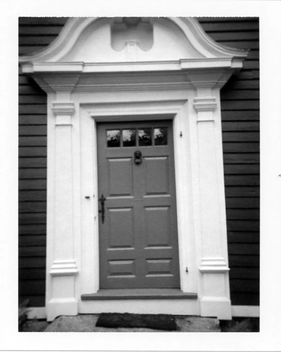 a gray door sits on a black and white building