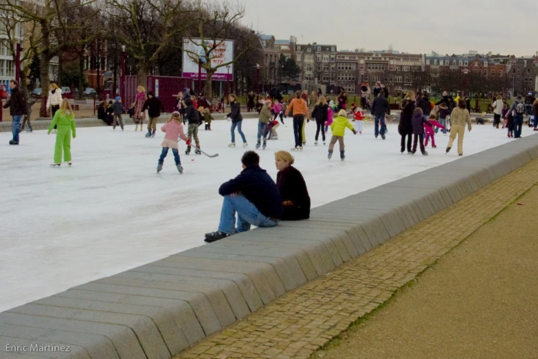 the people are skating in the large ice rink