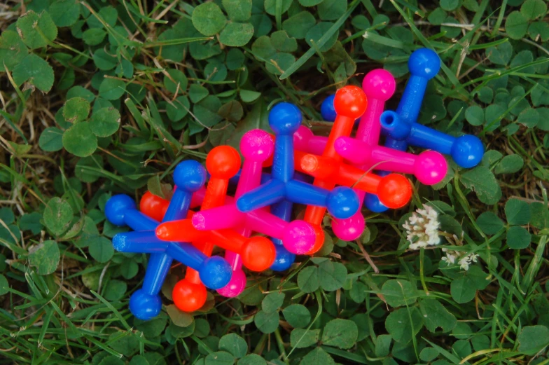 four different colored toys are sitting in the grass