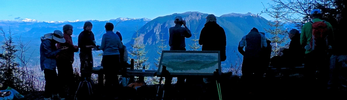 people standing at a cemetery near some mountains