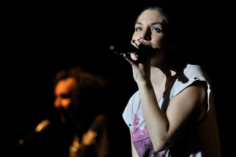 an image of woman singing into microphone at concert