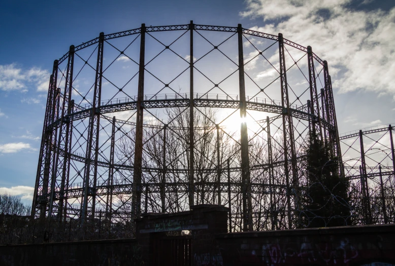 a sun over an abandoned roller coaster with graffiti on it