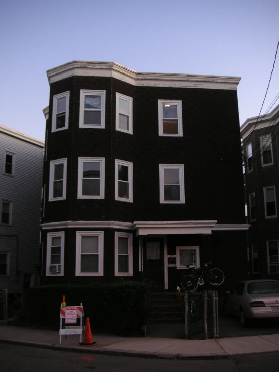 an apartment building with many windows, and a car parked in front