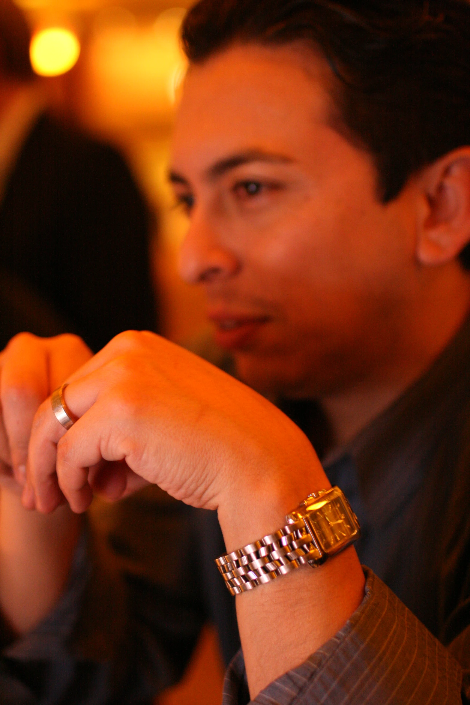 a young man sitting down while holding his hand out