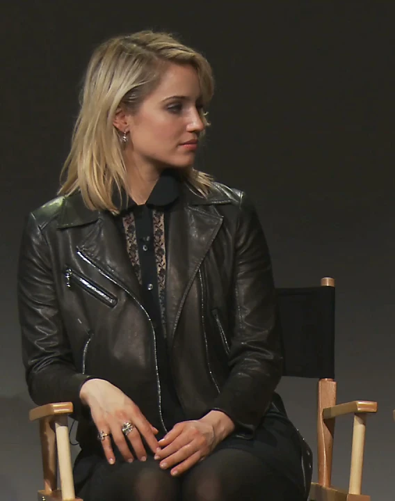 a woman in black sitting down on a chair