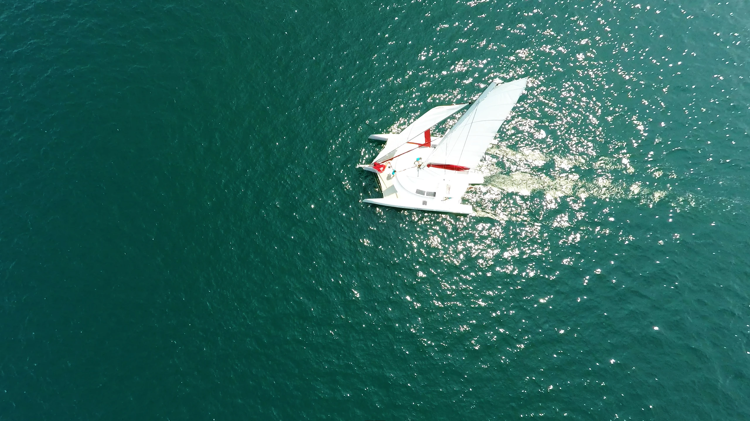 an aerial po of a white boat on the ocean