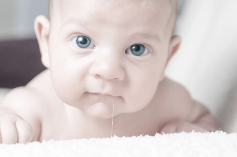 a very cute baby laying on top of a bed