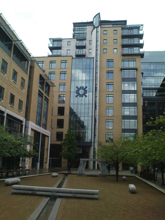 a modern building with a clock is seen behind another modern building