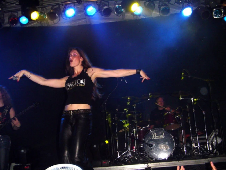a girl standing on a stage with her arms spread wide
