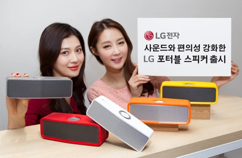 two beautiful young women holding up a sign next to some speakers