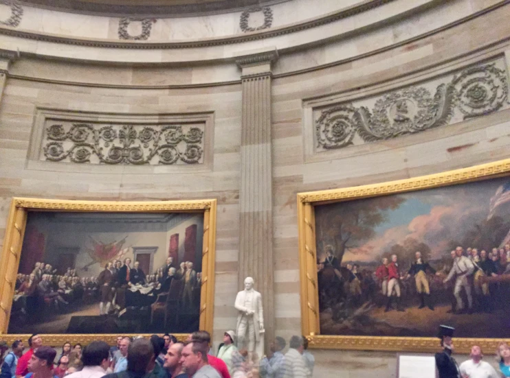 people are observing and taking pos of a large painting