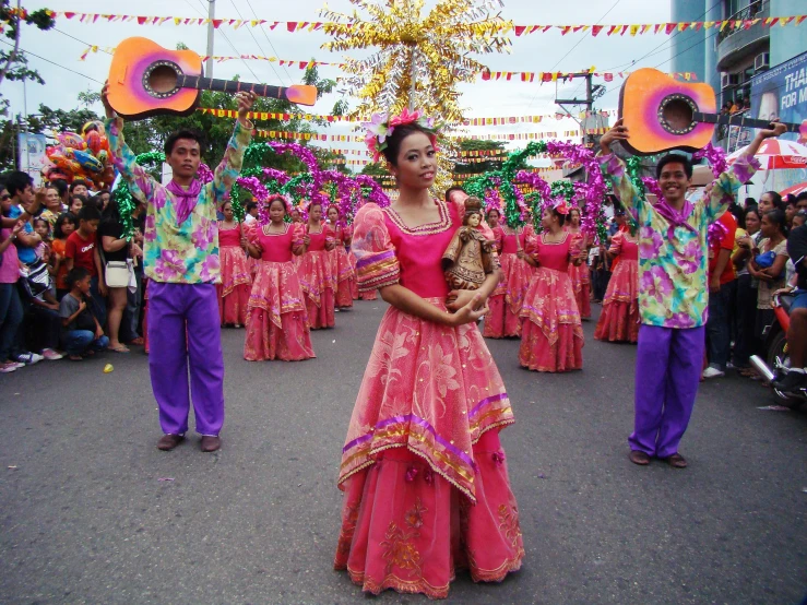 several people in colorful outfits and a parade with a person on a cart