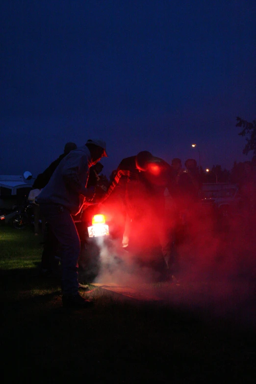 two men on top of an suv at night