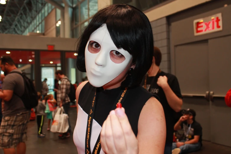 a woman wearing a mask and necklace at an event