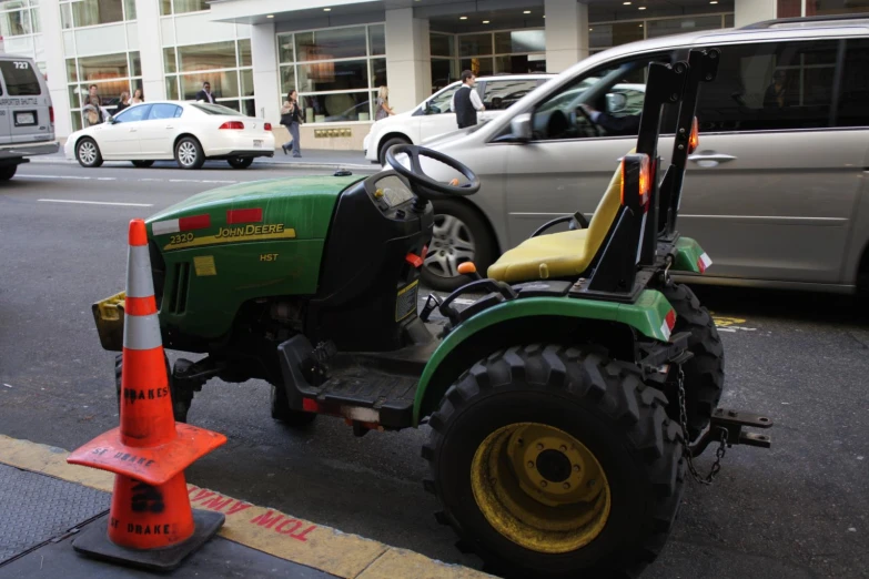 a green tractor sitting in the middle of the road