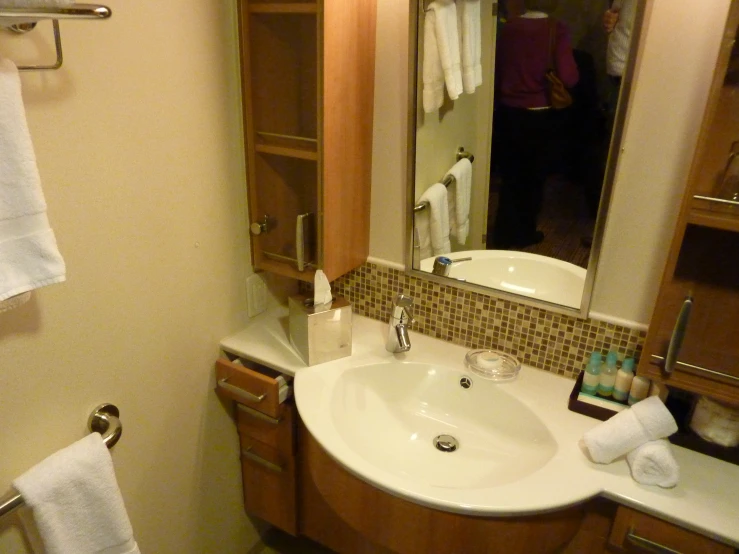 a clean bathroom with wooden cabinets and a mirror above it