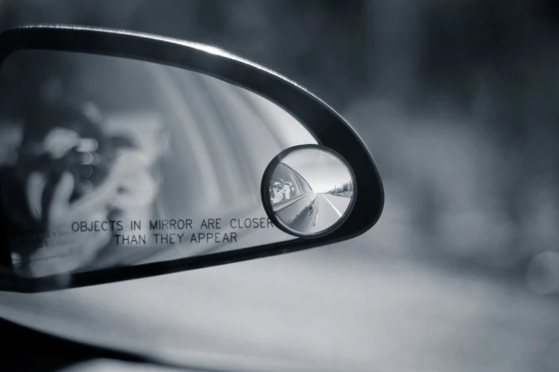 the reflection of a person on their side view mirror