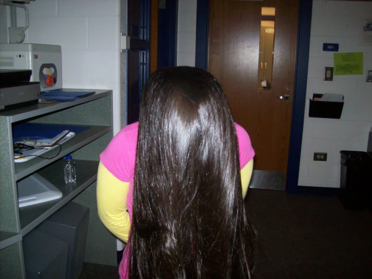 a woman with long brown hair in a pink shirt