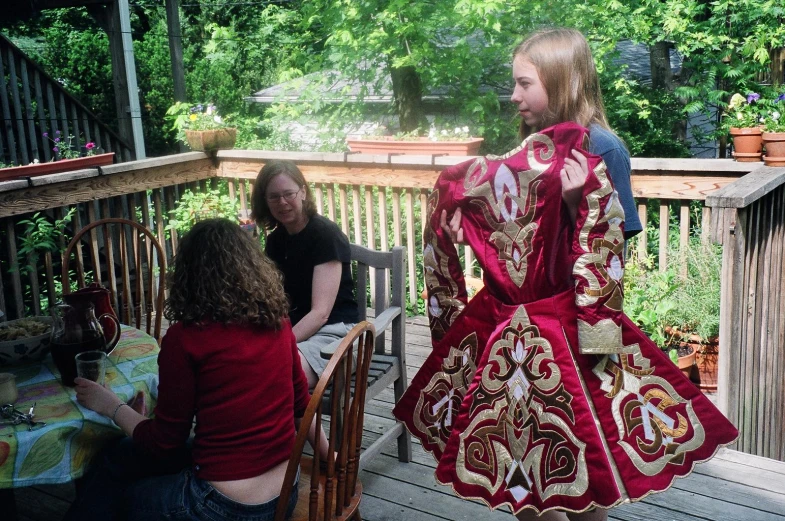 a woman in a long red dress holding her shawl