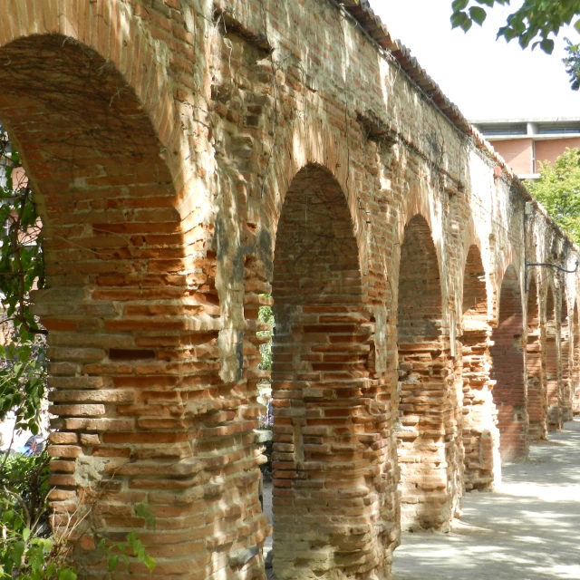 some arches hanging off a wall next to a sidewalk