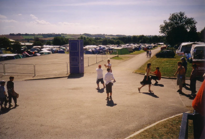 many people walking on a pavement in a parking lot