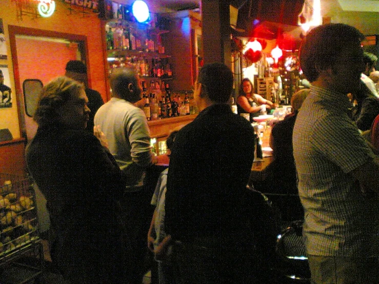 a crowd of people are standing at a bar