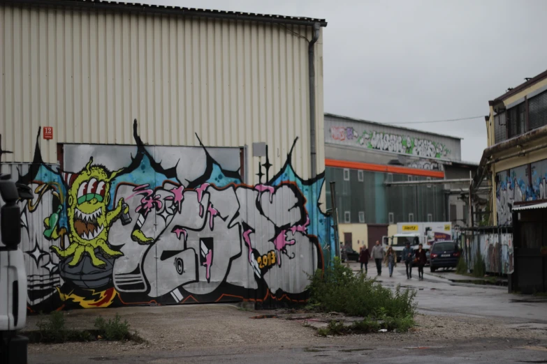 a wall with colorful graffiti on it in front of buildings