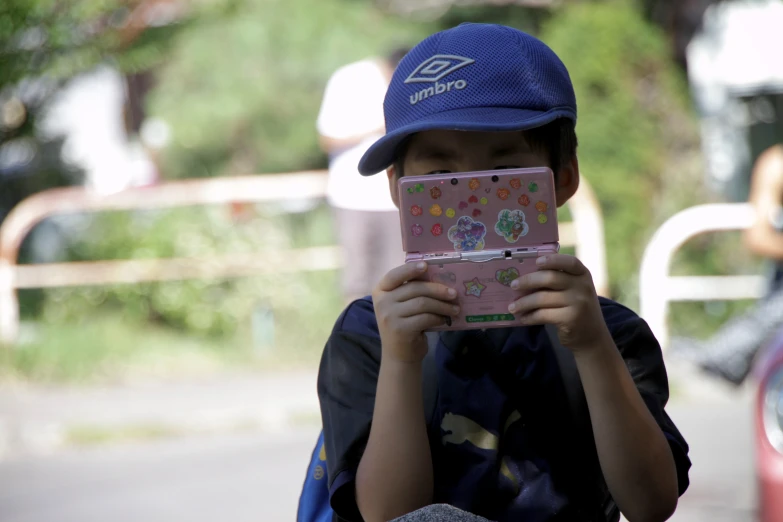 boy in baseball cap looking at a childs ipad