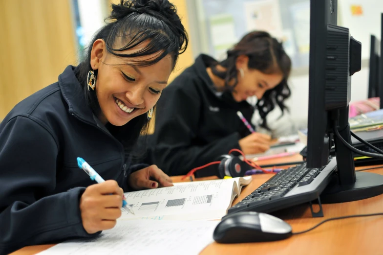 two students sitting at a desk working on an assignment