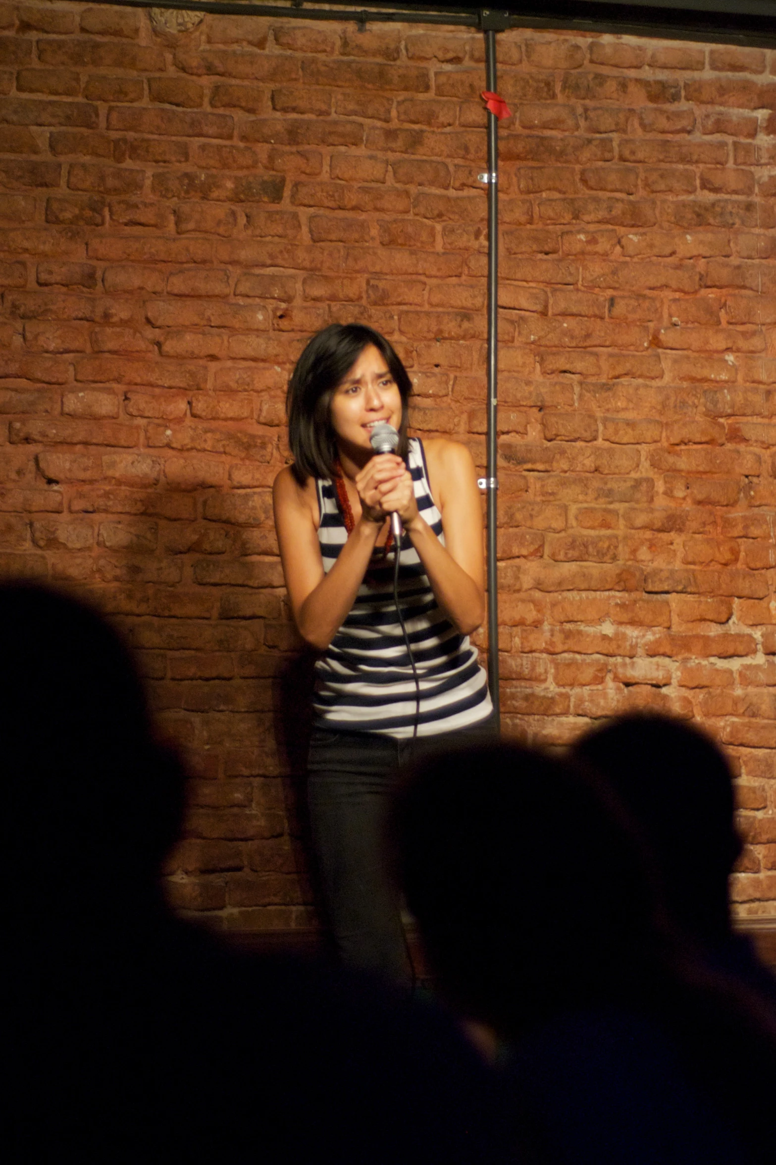 a girl on stage holding a microphone and performing