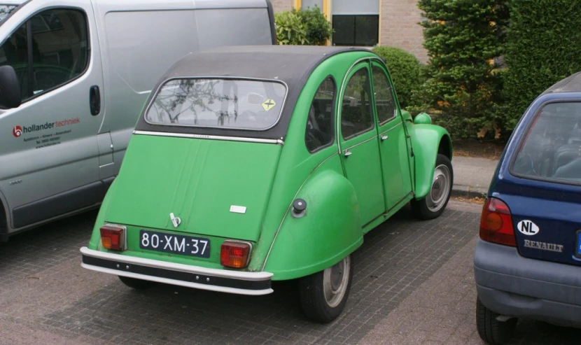 an old fashioned car is parked between two older ones