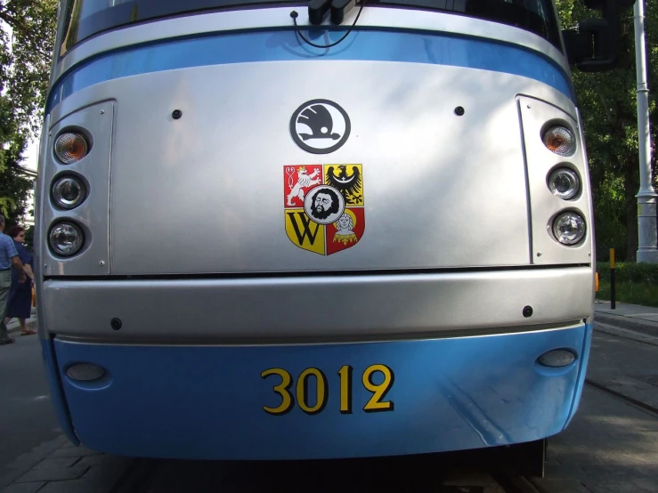 a close up view of the side of a silver and blue bus