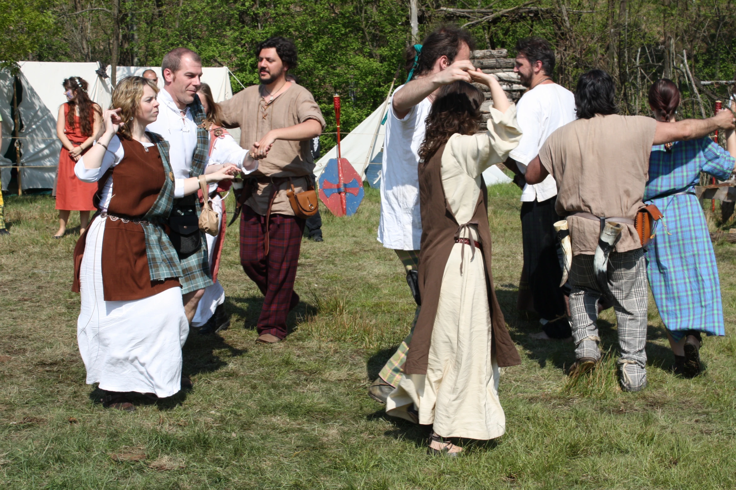 people in renaissance costumes in the field during a folk dance